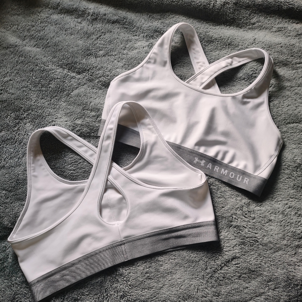 2 white Under Armour sports bras